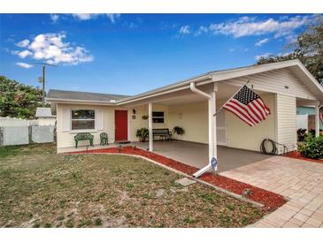 Charming single-story home featuring a covered parking area, red door, and an American flag at 5808 18Th W St # A & B, Bradenton, FL 34207