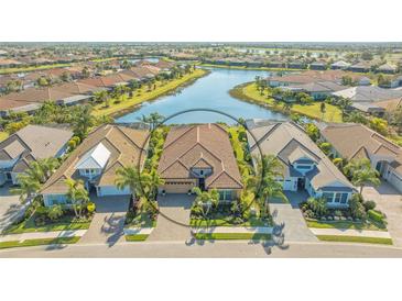 Stunning aerial view of a private home near a pond in a beautiful community with lush surroundings at 7213 Whittlebury Trl, Lakewood Ranch, FL 34202