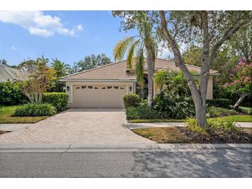 Lovely home features a paved driveway, tile roof, lush landscaping, and an attached two-car garage at 866 Placid Lake Dr, Osprey, FL 34229