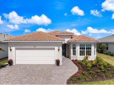 Charming single-story home with a tile roof, paver driveway, and beautifully landscaped front yard at 10240 Beach Dune Dr, Englewood, FL 34223
