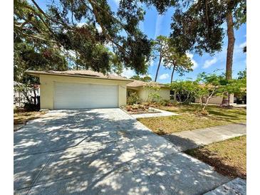Charming single story home with a two-car garage and a beautifully landscaped front yard at 1805 Springwood Dr, Sarasota, FL 34232