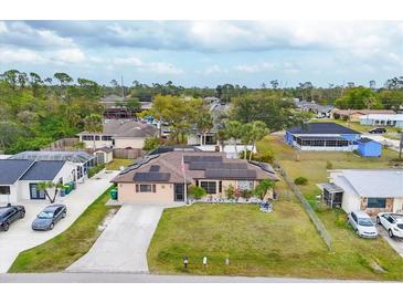 Charming single-story home featuring a well-manicured lawn and solar panels on the roof at 392 Yeager St, Port Charlotte, FL 33954