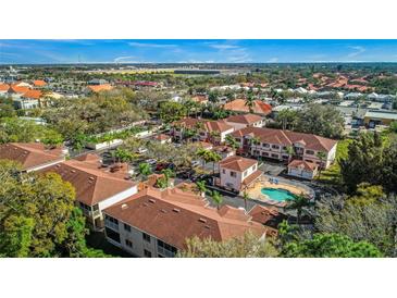 An aerial view shows the beautiful community with a pool, landscaping, and parking at 3958 Mediterranea Cir # 411, Sarasota, FL 34233