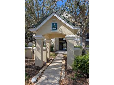 Inviting entrance to the building, featuring a covered walkway, lush landscaping, and well-maintained architecture at 5168 Northridge Rd # 102, Sarasota, FL 34238