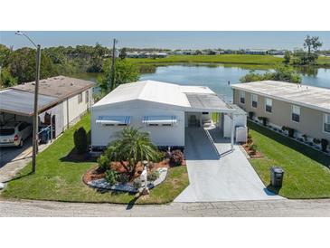 Charming home featuring lush landscaping and a covered carport, situated by a serene lake at 1416 41St E Ave, Ellenton, FL 34222