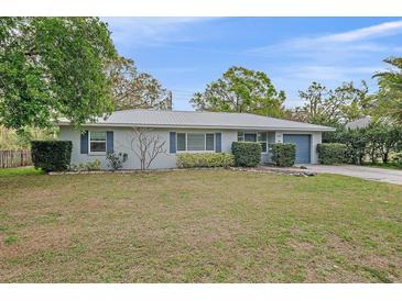 Charming one-story home boasts a well-manicured front lawn, complemented by mature landscaping and a gray metal roof at 1507 30Th W St, Bradenton, FL 34205