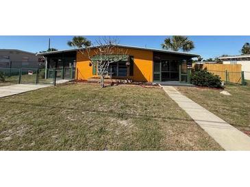 Charming single-story home featuring a bright yellow exterior, well-kept lawn, and inviting walkway to the entrance at 22332 Midway Blvd, Port Charlotte, FL 33952