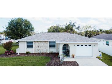 Charming single-story home with stone accents, an arched entryway, a well-manicured lawn, and an attached garage at 2412 15Th W St, Palmetto, FL 34221