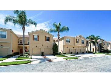 Inviting townhome exteriors with attached garages, complemented by palm trees and well-maintained landscaping at 3478 Parkridge Cir # 32-104, Sarasota, FL 34243