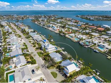 Stunning aerial view of waterfront property featuring lush landscaping, private dock, and canal access to the open bay at 511 68Th St, Holmes Beach, FL 34217