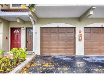 Attached garage featuring brown garage doors and matching entry doors in a well-maintained complex at 5700 Bentgrass Dr # 209, Sarasota, FL 34235