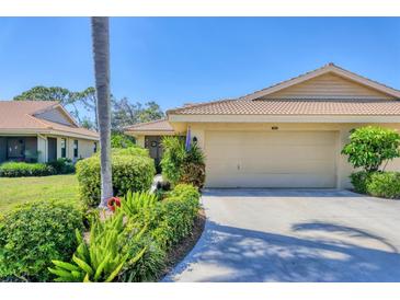 Charming home with a two-car garage, lush landscaping, and a tile roof at 7223 Wood Creek Dr # 22, Sarasota, FL 34231