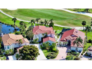 Stunning aerial view of the home situated on a golf course with lush landscaping and mature trees at 8025 Via Fiore, Sarasota, FL 34238
