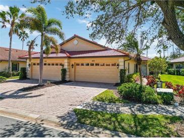 Inviting exterior view showcasing a well-maintained villa with a red tile roof and a two-car garage at 4122 Bella Pasque, Venice, FL 34293