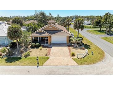Beautiful home featuring a brick driveway, two-car garage, and lush landscaping at 417 Tortuga Dr, Nokomis, FL 34275