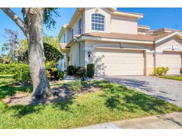 Two-story home featuring a two car garage, terracotta roof, and a well-maintained landscaped yard at 4480 Cinnamon Dr # 2408, Sarasota, FL 34238
