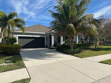 Beautiful single-story home featuring a spacious driveway, two-car garage, and lush tropical landscaping at 5262 Asher Ct, Sarasota, FL 34232