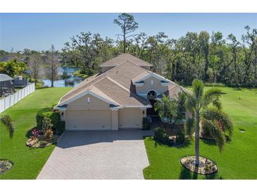 Stunning single-Gathering home featuring a large 3 car garage, brick driveway, lush landscaping, and tranquil waterfront views at 5412 72Nd E Ter, Ellenton, FL 34222