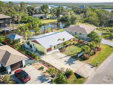 Aerial view of a charming property with defined borders, featuring mature landscaping and water access at 9031 Hilolo Ln, Venice, FL 34293