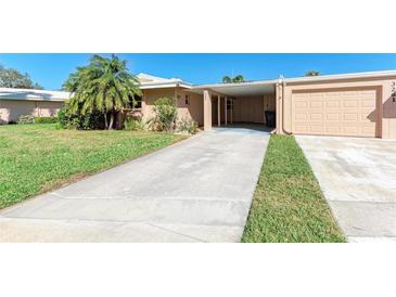 Charming single-story home featuring a driveway, carport, and attached garage at 3259 Fairhaven Ln # 211, Sarasota, FL 34239