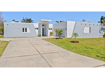 Modern, gray and white home featuring a concrete driveway and minimalist landscaping at 3319 Mayflower St, Sarasota, FL 34231