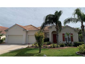 Charming single-story home featuring a well-manicured lawn, mature palm trees, and a terracotta tile roof at 4506 62Nd E Ter, Bradenton, FL 34203