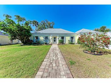 Charming single-story home with well-manicured lawn, brick walkway, and light-yellow exterior at 5 Barbados Rd # 31, Englewood, FL 34223