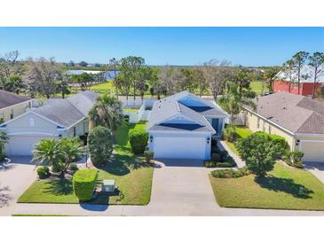 Charming single-story home with a well-manicured lawn and mature landscaping, complemented by a driveway and attached garage at 5234 Aqua Breeze Dr, Bradenton, FL 34208