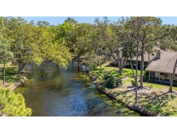 Picturesque backyard with a serene canal view surrounded by lush greenery at 5655 Pipers Waite # 27, Sarasota, FL 34235