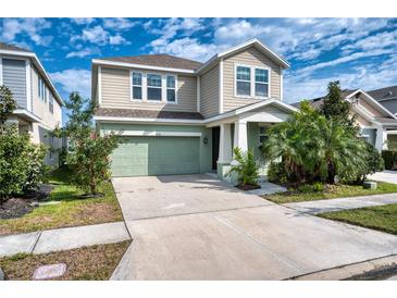 Charming two-story home with a well-manicured lawn and attached two-car garage at 6136 Voyagers Pl, Apollo Beach, FL 33572