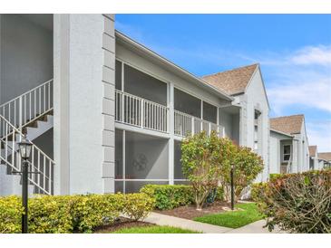 Condominium exterior featuring screened lanais, mature landscaping, and convenient stairwell access at 6707 Stone River Rd # 105, Bradenton, FL 34203