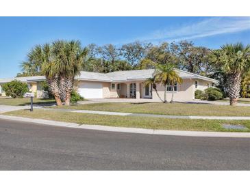 Beautiful single-story home with a well-manicured lawn and mature landscaping at 7211 Antigua Pl, Sarasota, FL 34231