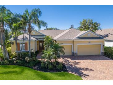 Charming one-story home with a brick driveway, three-car garage, and lush landscaping including several palm trees at 8861 17Th Avenue Nw Cir, Bradenton, FL 34209