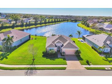 Beautiful single-Gathering home with manicured lawn overlooking a serene lake in a peaceful neighborhood at 1014 Calico Gln, Bradenton, FL 34212