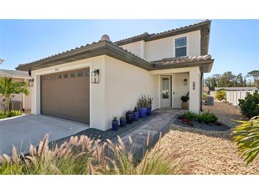 Charming two-story home with well-manicured landscaping and a paved walkway to the front door at 1876 Livingstone St, Sarasota, FL 34231