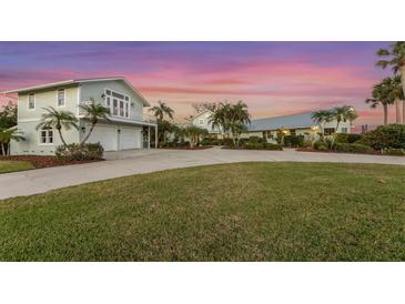 Inviting two story coastal home with lush landscaping, a circular driveway, and a two car garage at 336 S Orchid Dr, Ellenton, FL 34222