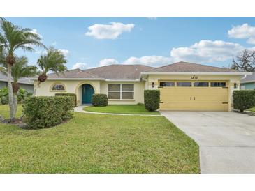 Charming single-story home featuring lush landscaping, a well-manicured lawn, and a colorful front door at 3419 31St E St, Bradenton, FL 34208