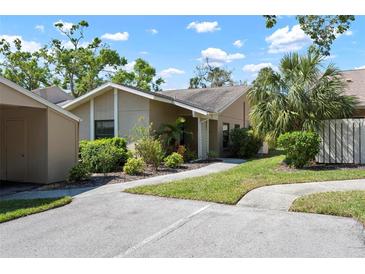 Home featuring manicured lawn, sidewalk, and shade trees at 3461 Tallywood Cir # 7067, Sarasota, FL 34237