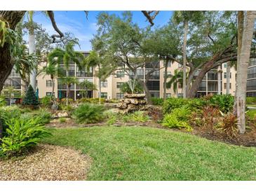 Lovely condo exterior featuring a fountain and landscaped garden with beautiful mature shade trees at 515 30Th Ave W # H410, Bradenton, FL 34205