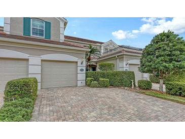 Charming home exterior features a three-car garage and well-manicured landscaping at 5211 Parisienne Pl # 101B27, Sarasota, FL 34238