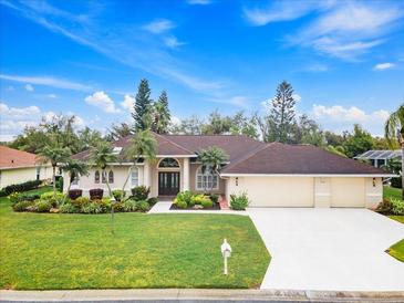 Lovely single-story home showcasing a well-manicured lawn and attractive landscaping at 5662 Country Lakes Dr, Sarasota, FL 34243