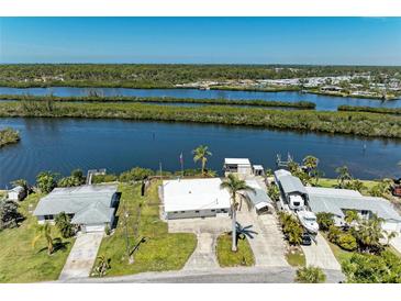 Waterfront home featuring a private dock, lush landscaping, and boat lift at 603 Ravenna N St, Nokomis, FL 34275