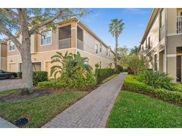 Charming multi-Gathering home with lush landscaping and a brick walkway leading to the entrance at 7959 Limestone Ln # 14-104, Sarasota, FL 34233