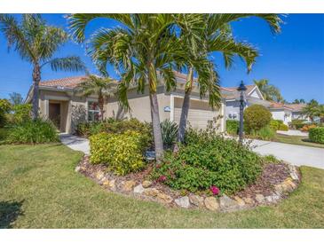 Charming single-story home boasts lush landscaping, mature palms, and a well-manicured lawn at 21037 Anclote Ct, Venice, FL 34293