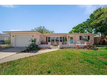 Charming single-story home boasts a well-manicured lawn, inviting porch, and lovely landscaping at 260 Hammock Ter, Venice, FL 34293
