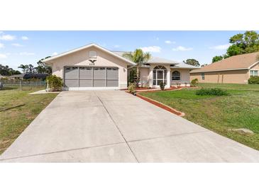 Home's exterior showcasing the driveway, front yard, and a two-car garage at 4268 Mulgrave Ave, North Port, FL 34287