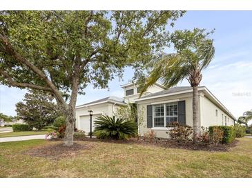 Charming single-story home with a well-manicured front yard, mature trees and attached garage at 4691 Claremont Park Dr, Bradenton, FL 34211