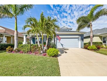 Charming single-story home boasts a two-car garage, a lush lawn with tropical landscaping, and a paver driveway at 7012 White Willow Ct, Sarasota, FL 34243
