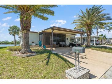 Charming single-story home with well-maintained lawn, palm trees, a carport, and cozy outdoor seating area at 772 Imperial Dr, North Port, FL 34287