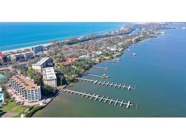 Stunning aerial view of beachfront condos, private docks, and turquoise waters at 8625 Midnight Pass Rd # 305B, Sarasota, FL 34242